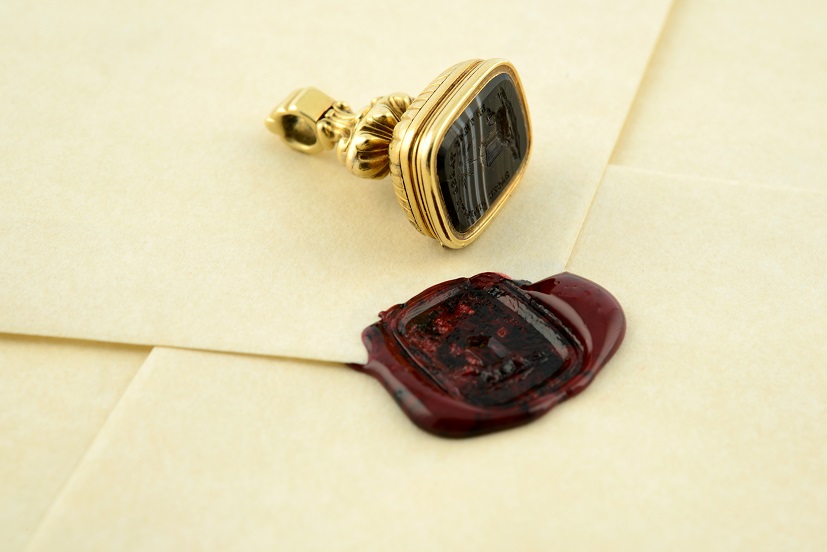 A late Georgian/William IV 15ct gold banded agate mourning fob, with hinged glazed compartment for Arthur Tyrwhitt Drake